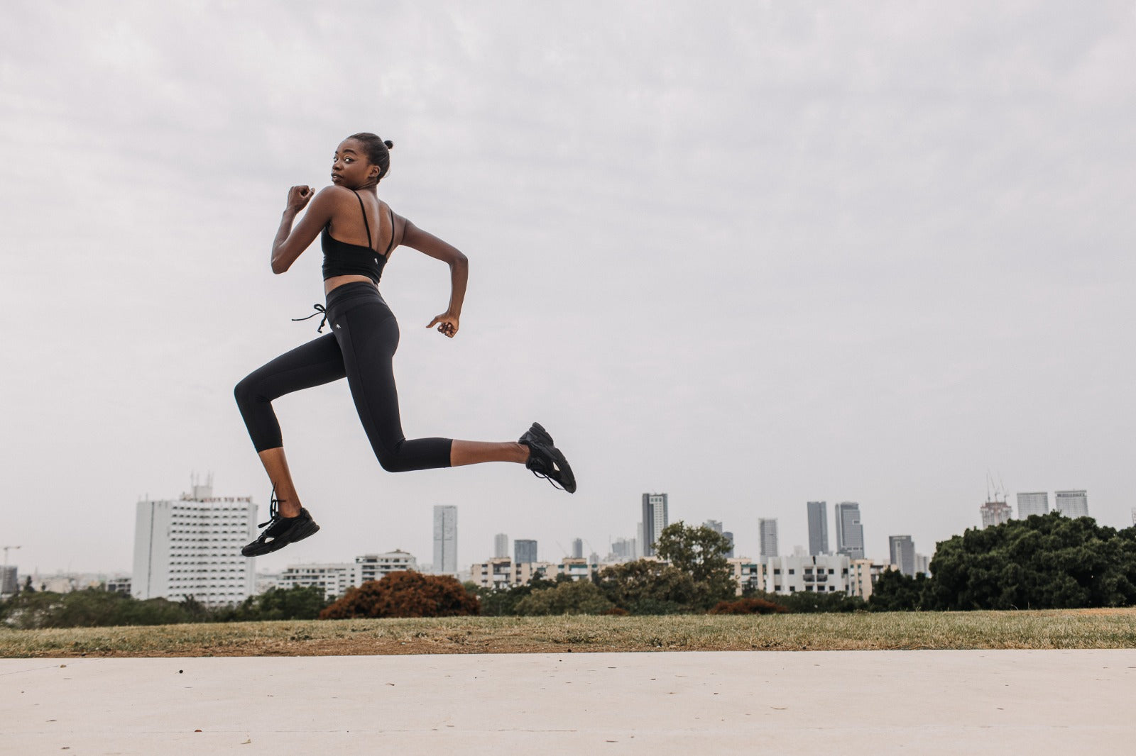 A woman dressed in raven sportswear in a jump